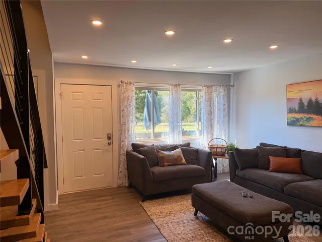 a kitchen with stainless steel appliances granite countertop a refrigerator a stove a sink a dining table and chairs