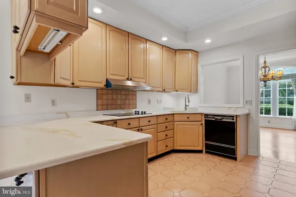 a kitchen with stainless steel appliances granite countertop a sink a stove and white cabinets with wooden floor