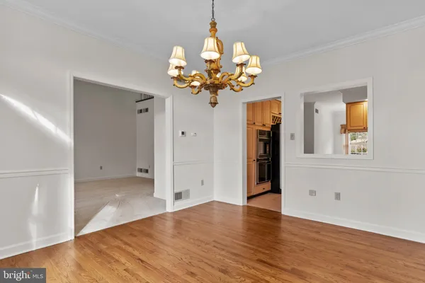 a view of a room with wooden floor and chandelier