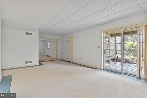 an empty room with a ceiling fan and windows