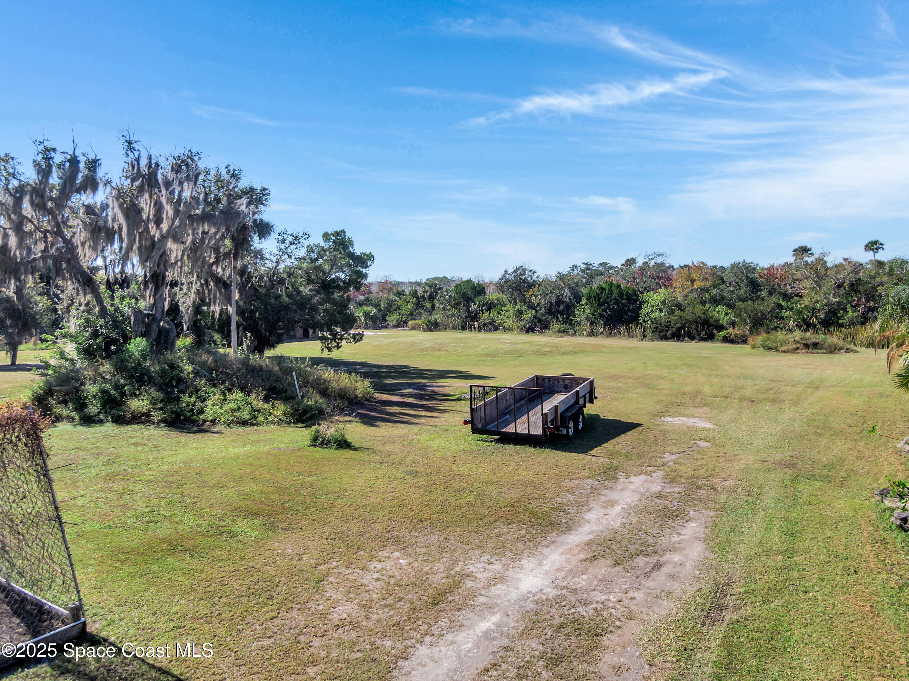 875 Pine Island Road Merritt Island, FL 32953 - Photo 24 of 24 a view of a field with some trees in the background