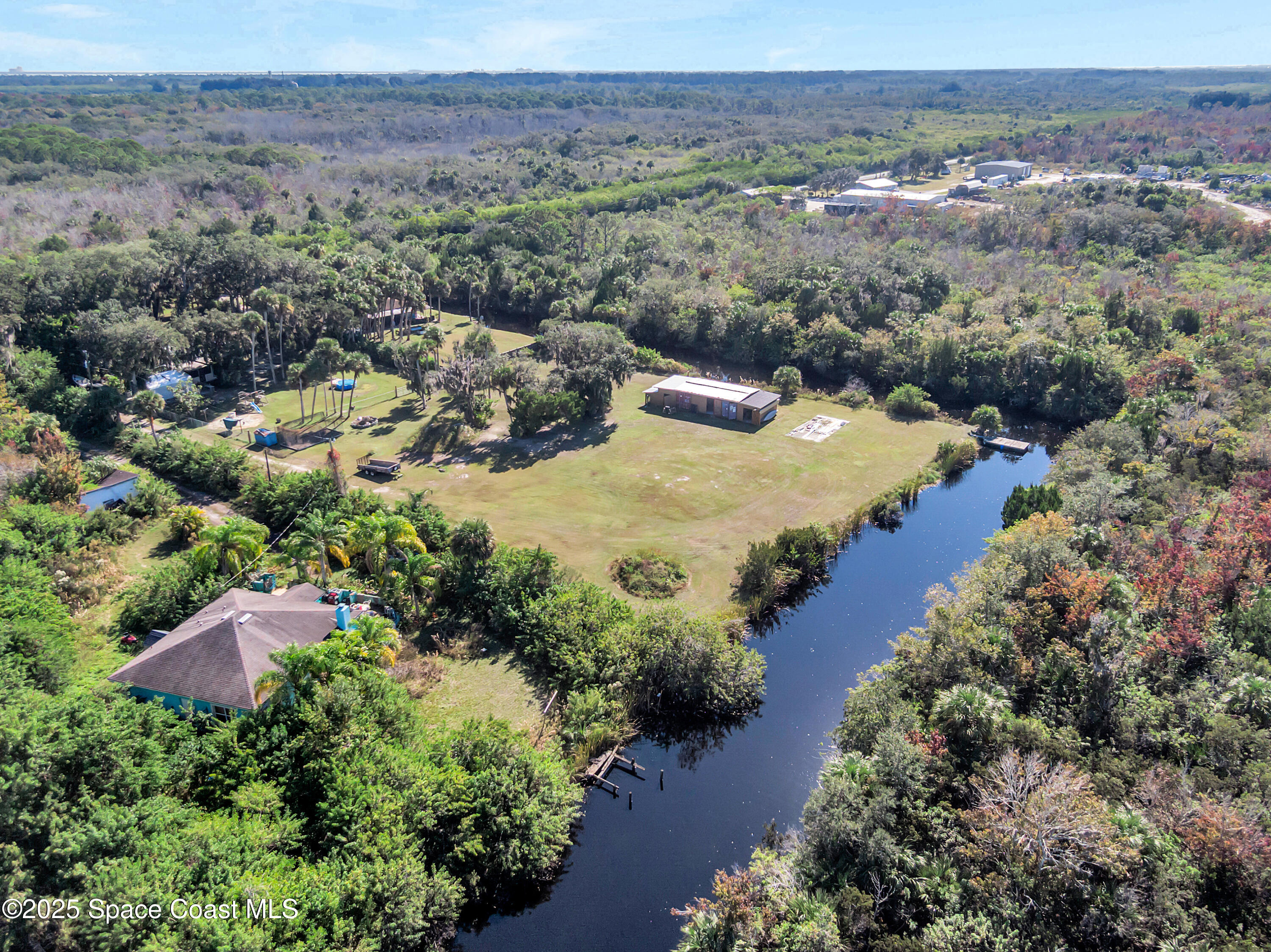 875 Pine Island Road Merritt Island, FL 32953 - Photo 4 of 24 an aerial view of green landscape with trees houses and mountain view