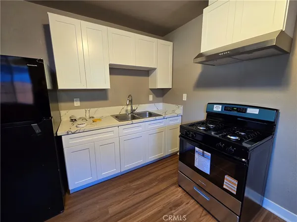 a kitchen with sink stove and cabinets