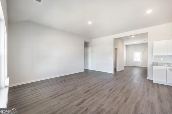 a view of empty room with wooden floor