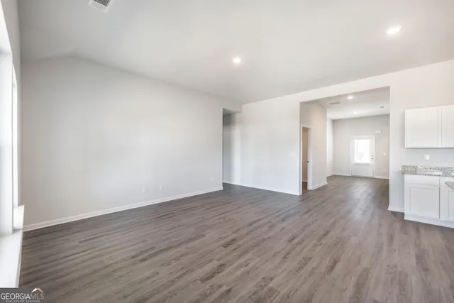 a view of empty room with wooden floor
