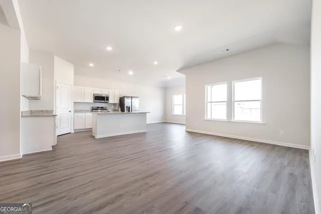 a view of kitchen with wooden floors appliances and cabinets