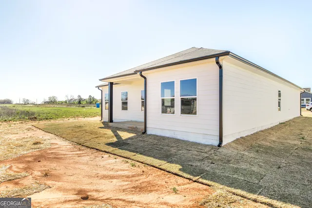 a view of a house with backyard and trees