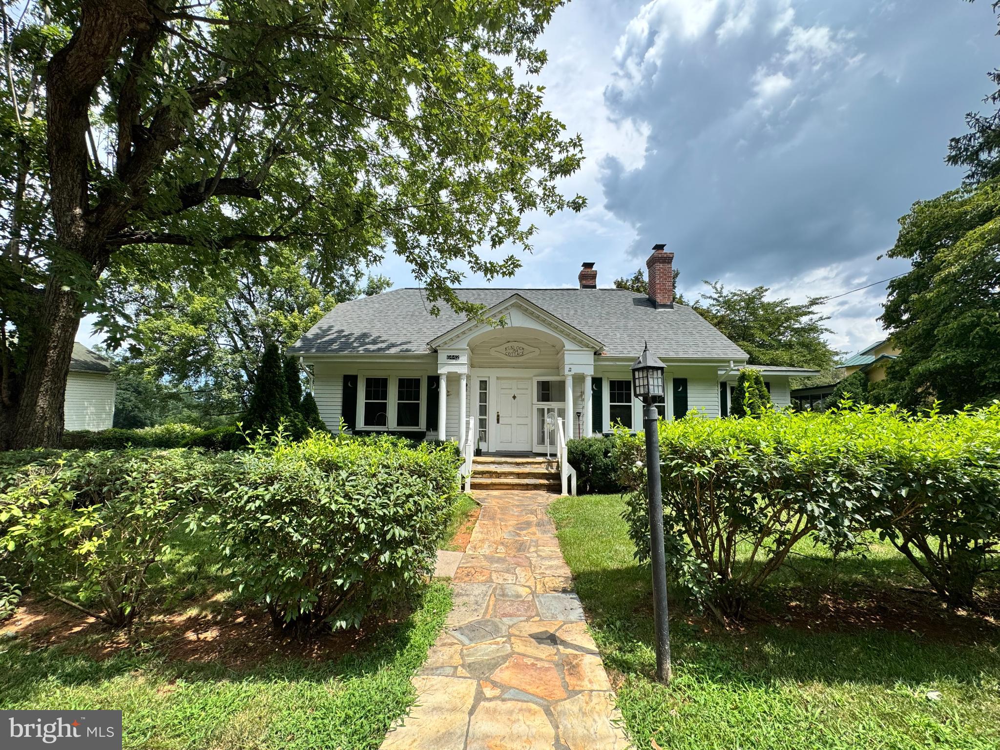 Charming home framed by lush greenery.
