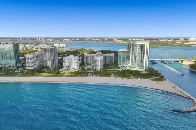 an aerial view of residential houses with outdoor space and ocean view
