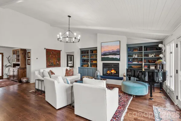 a living room with furniture a fireplace and a chandelier