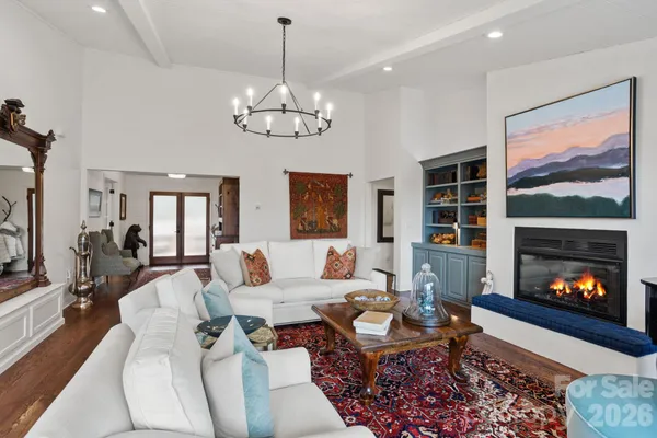 a living room with furniture a chandelier and a fireplace