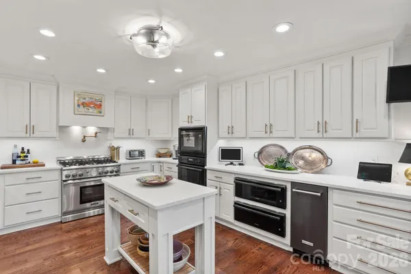 a kitchen with stainless steel appliances a stove a sink and cabinets