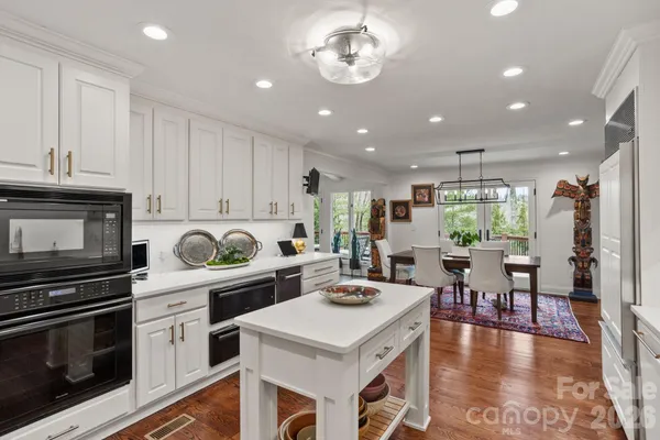 a kitchen with a stove a microwave and wooden floor