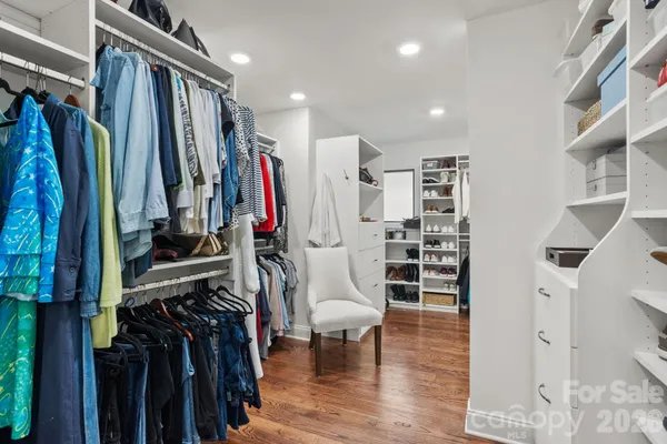 a view of walk in closet with clothes and shoes