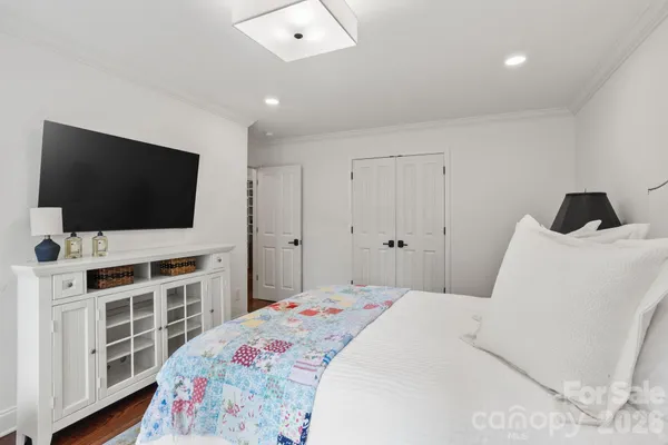 a bedroom with a bed and a flat screen tv