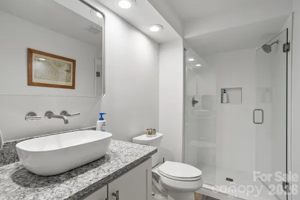a bathroom with a granite countertop sink toilet and shower