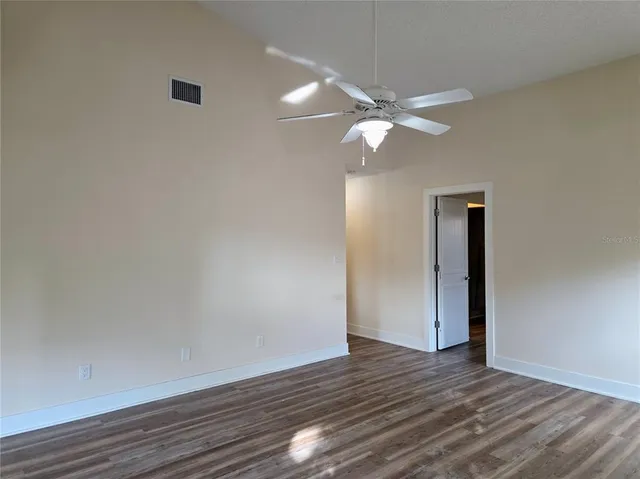 a view of an empty room with wooden floor