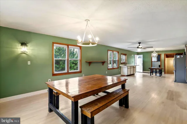 a dining room with wooden floor a chandelier table and chairs