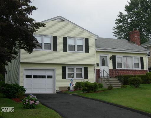 100 Clovelly Road Stamford, CT 06902 - Photo 1 of 1 a front view of a house with a garden and yard