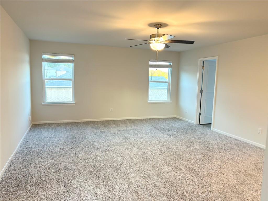 6901 Durham Lane Fairburn, GA 30213 - Photo 13 of 29 an empty room with a chandelier fan and windows