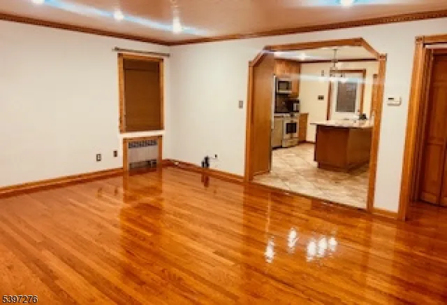 en empty room with wooden floor and windows