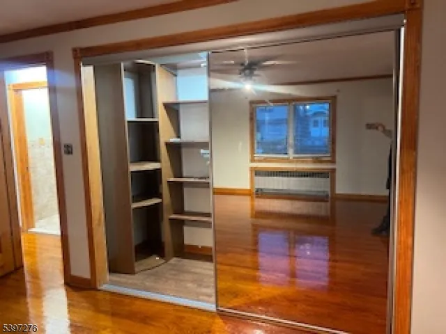 a view of a hallway with wooden floor and dining room