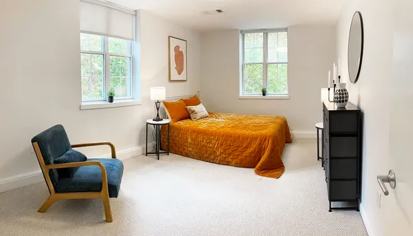 a bedroom with a bed a mirror and a window