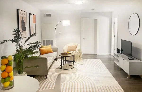 a living room with furniture a flat screen tv and a large window