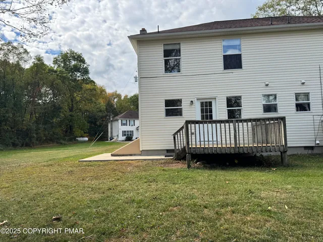a view of a house with a backyard and deck