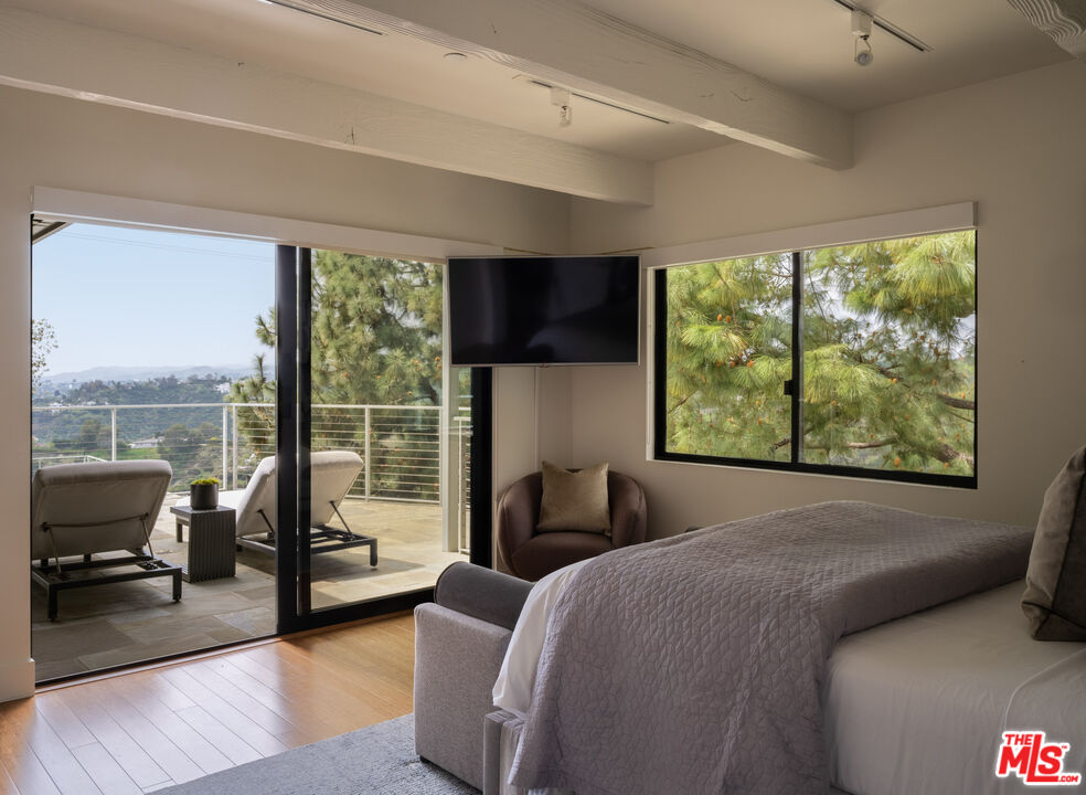 1575 Carla Ridge Beverly Hills, CA 90210 - Photo 26 of 39 a bedroom with furniture and a large window