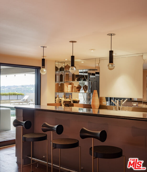 1575 Carla Ridge Beverly Hills, CA 90210 - Photo 31 of 39 a kitchen with a sink and chairs