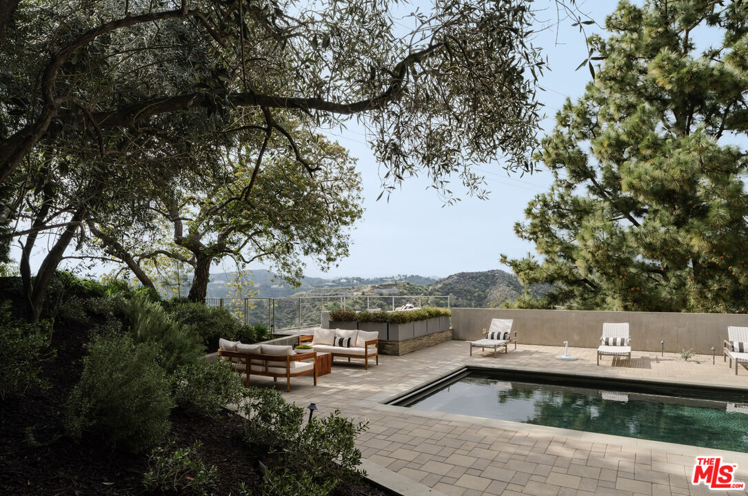 1575 Carla Ridge Beverly Hills, CA 90210 - Photo 36 of 39 a view of a swimming pool with a lounge chairs