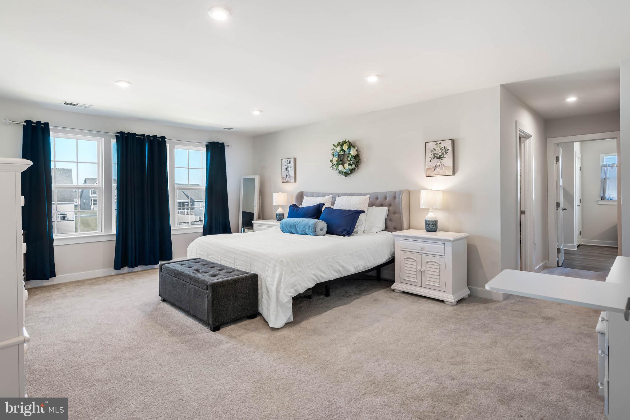 19079 Trimaran Drive Lewes, DE 19958 - Photo 27 of 61 a spacious bedroom with a bed a couch and a window