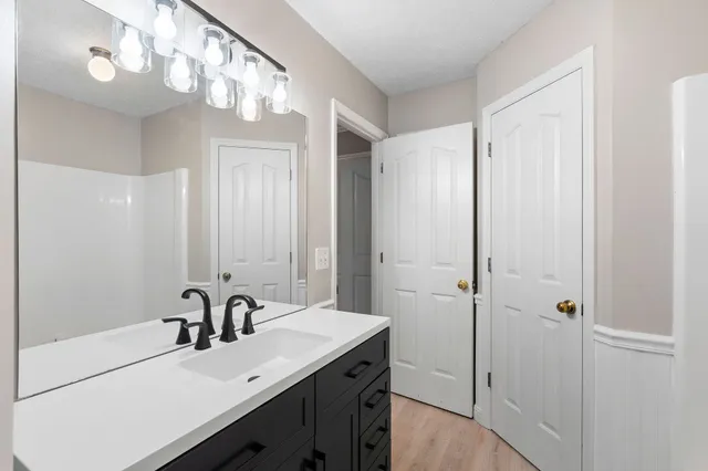 a bathroom with a sink a mirror and a shower
