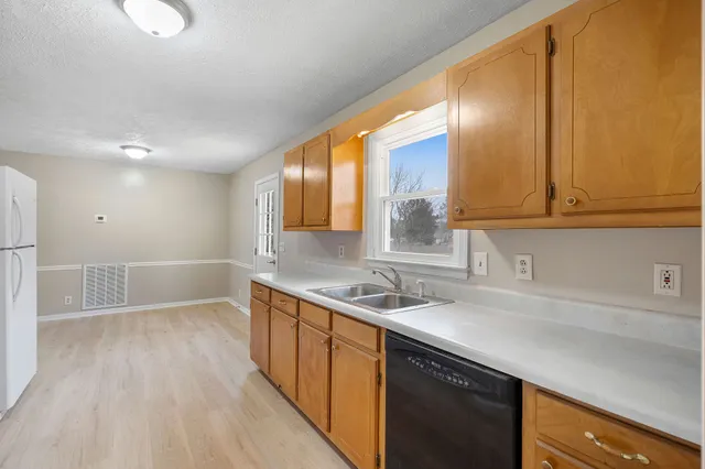a kitchen with a sink a stove cabinets and a wooden floor