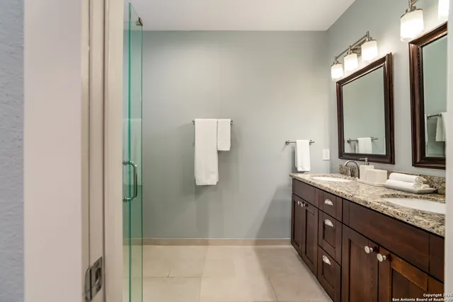 a bathroom with a granite countertop sink and a mirror