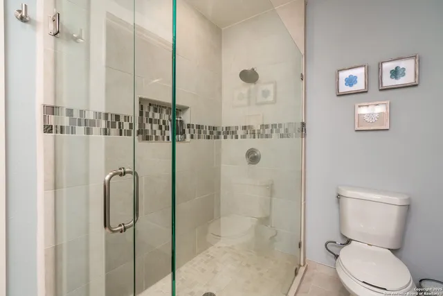 a bathroom with a toilet and a shower