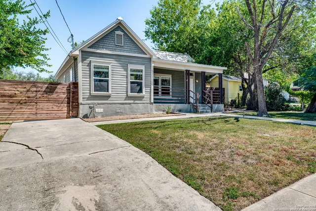 a front view of house with yard and trees in the background