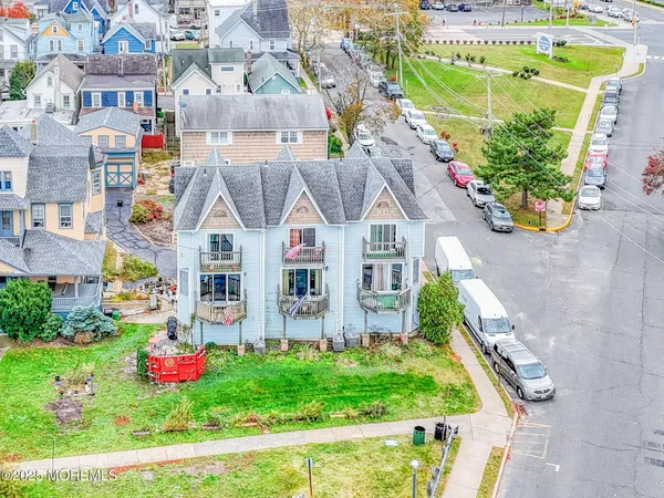 a front view of multiple houses with yard