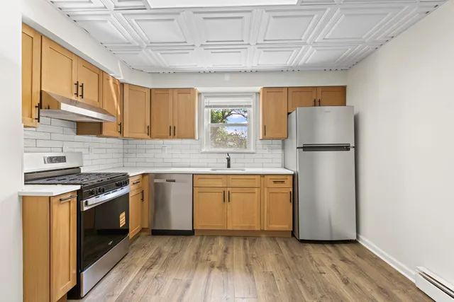 a kitchen with sink a refrigerator and white cabinets