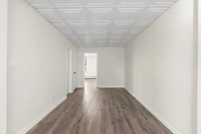 a view of a room with wooden floor and white walls