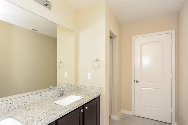 a bathroom with a granite countertop sink and a mirror