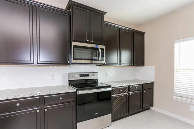 a kitchen with stainless steel appliances a sink stove and microwave