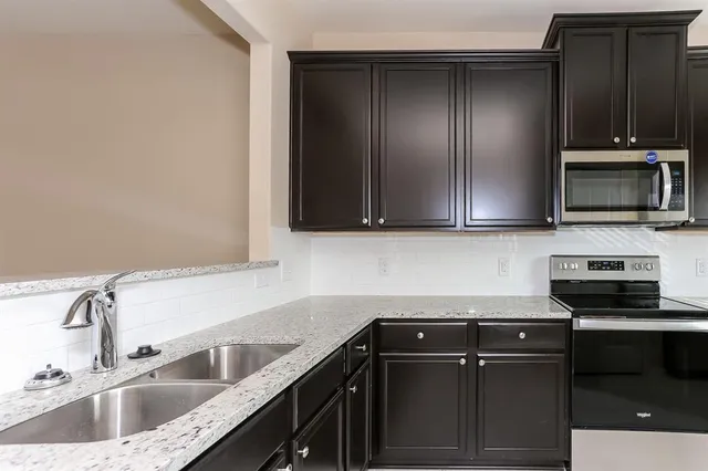 a kitchen with a sink and steel appliances