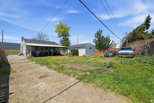 7879 Oak Street Midvale, UT 84047 - Photo 31 of 32 Rear exterior featuring a covered patio, pitched roof, and a detached shed