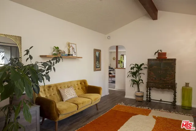 a living room with furniture a flat screen tv and a table