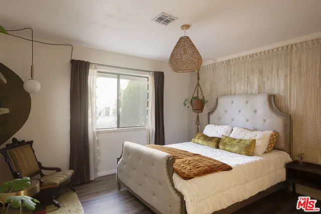 a bedroom with a bed and wooden floor