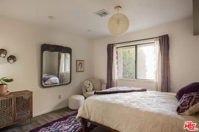 a bedroom with a bed mirror and window
