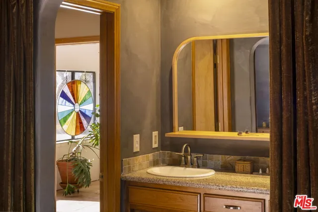 a bathroom with a granite countertop sink and a mirror