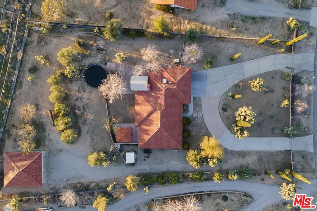 an aerial view of a house with a pool and a yard